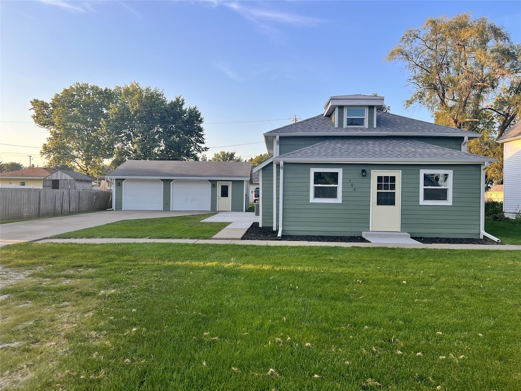 view of front facade with an outdoor structure, a garage, and a front lawn