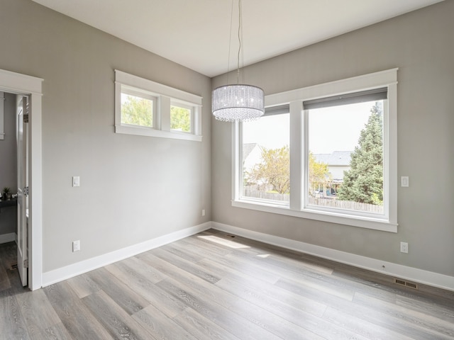 interior space featuring light wood-type flooring and an inviting chandelier