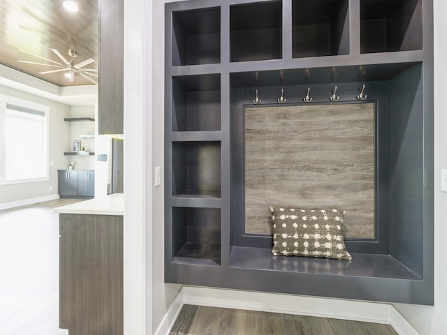 mudroom with built in shelves and wood-type flooring