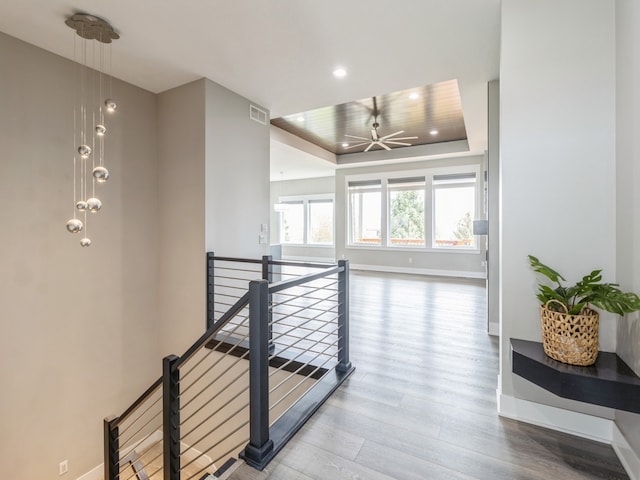 hallway featuring hardwood / wood-style floors and a raised ceiling