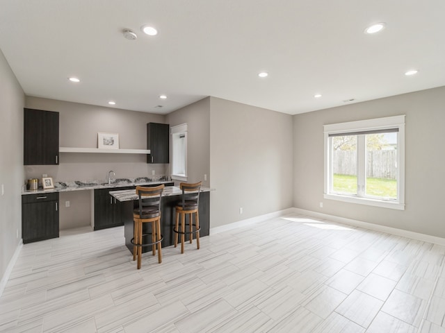 kitchen featuring a kitchen breakfast bar, a center island, and sink