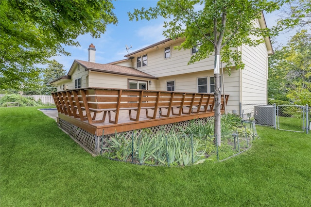 back of property with a wooden deck and a lawn