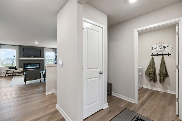 corridor featuring recessed lighting, baseboards, and light wood finished floors