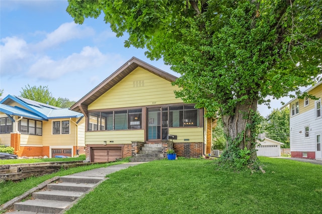 view of front of home with a sunroom, a garage, and a front lawn