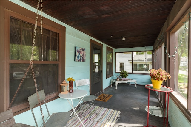 sunroom / solarium featuring wooden ceiling and a healthy amount of sunlight