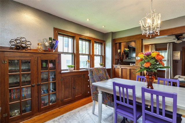 dining space with light wood-style floors, ceiling fan with notable chandelier, and recessed lighting