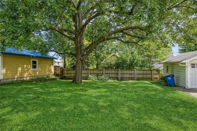 view of yard with fence and an outbuilding