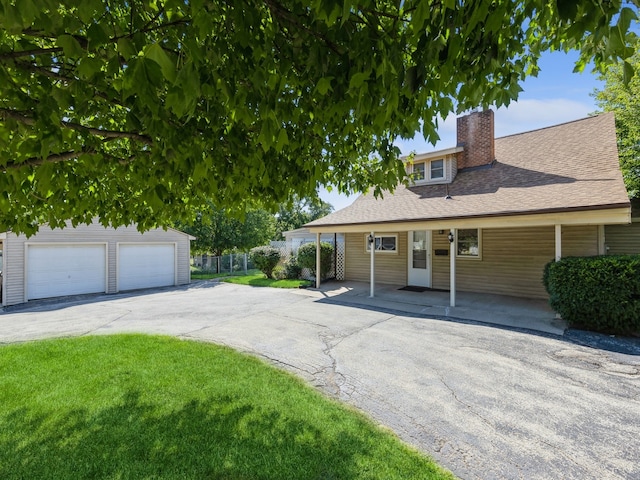 view of front facade featuring a garage, a front lawn, and a carport