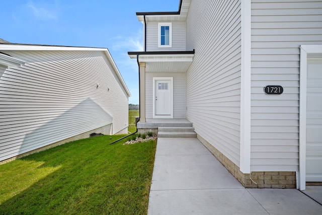 entrance to property with a lawn