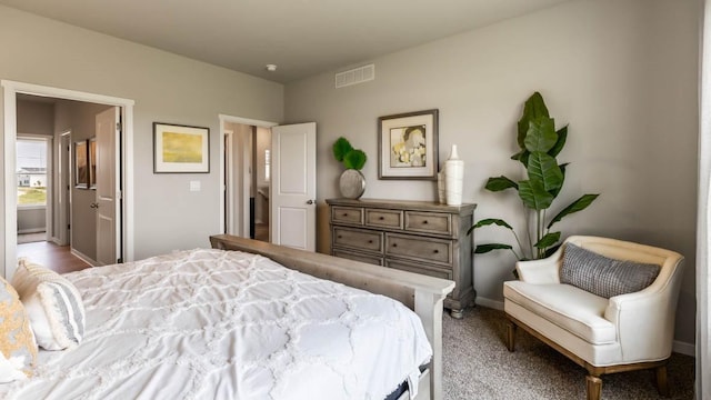 bedroom featuring visible vents, ensuite bath, and baseboards