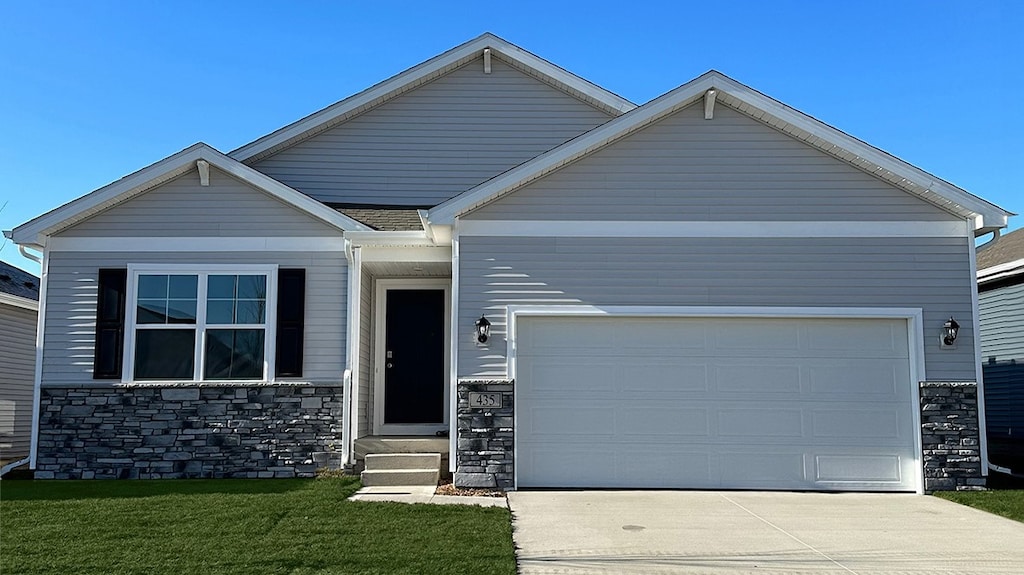 craftsman house featuring a garage and a front lawn