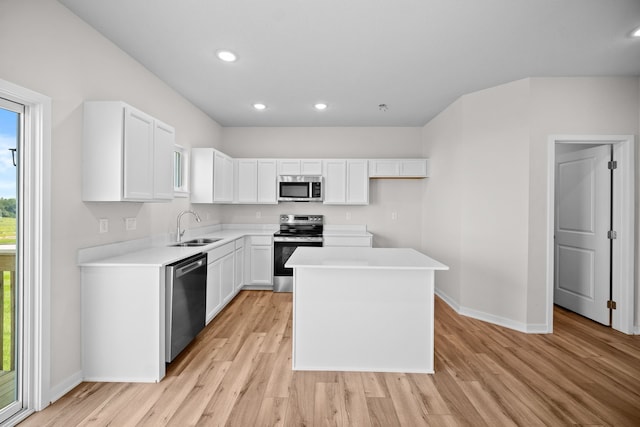 kitchen with light hardwood / wood-style floors, sink, stainless steel appliances, and white cabinets