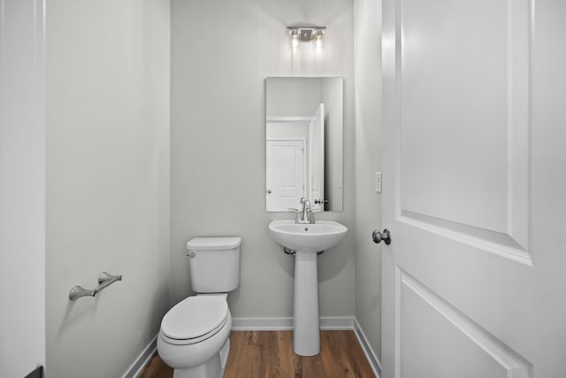 bathroom featuring wood-type flooring and toilet