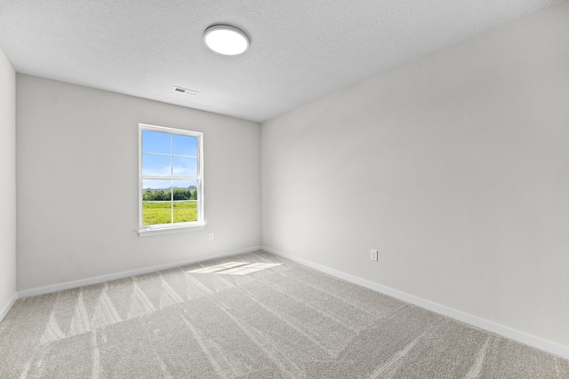 unfurnished room with carpet floors and a textured ceiling