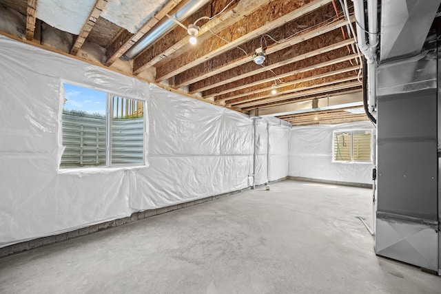 basement featuring a healthy amount of sunlight and heating unit