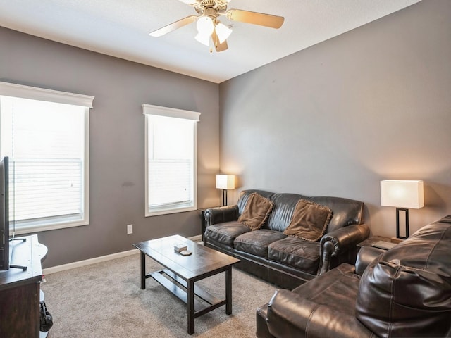 living room with baseboards, ceiling fan, and carpet flooring