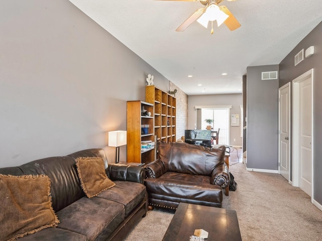 living room featuring visible vents, light colored carpet, a ceiling fan, and baseboards