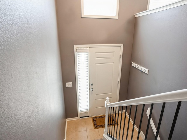 tiled entryway with baseboards and plenty of natural light