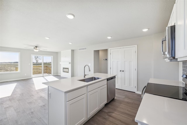 910 Willow Valley Dr, Norwalk, IA 50211 - kitchen featuring a sink, stainless steel appliances, light countertops, white cabinetry, and wood finished floors