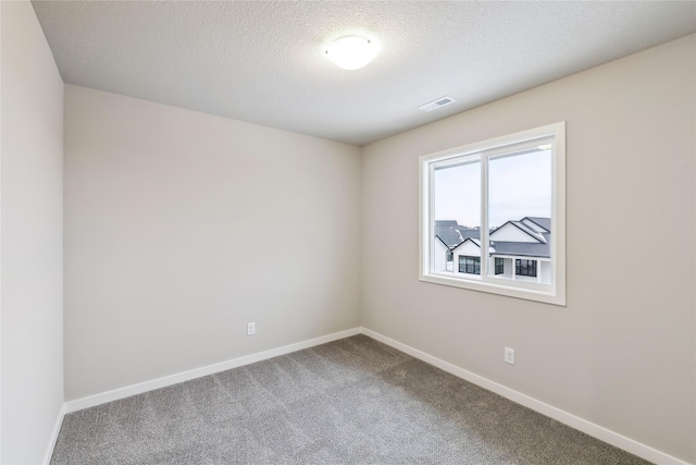 carpeted spare room with a textured ceiling