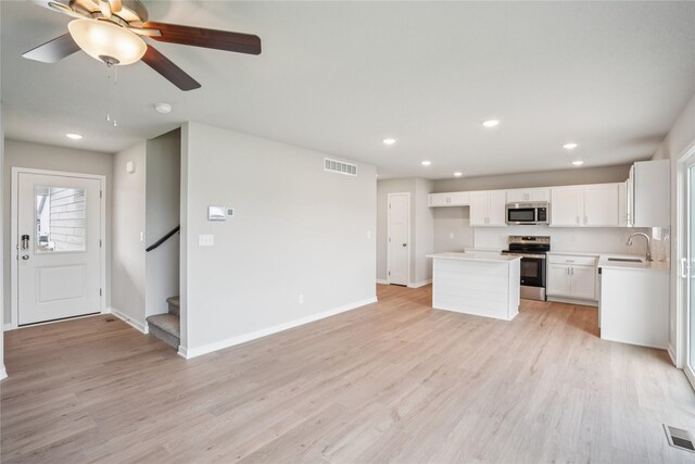 18025 Alpine Dr, Clive, IA 50325 - unfurnished living room with a sink, light wood-type flooring, baseboards, recessed lighting, and stairs