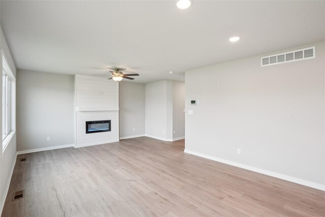 18025 Alpine Dr, Clive, IA 50325 - unfurnished living room featuring a ceiling fan, light wood-type flooring, baseboards, a large fireplace, and recessed lighting