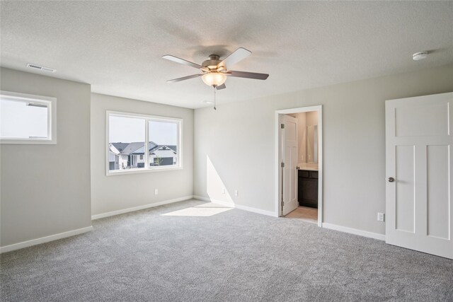 18025 Alpine Dr, Clive, IA 50325 - unfurnished bedroom with light colored carpet, multiple windows, a textured ceiling, baseboards, and ensuite bathroom