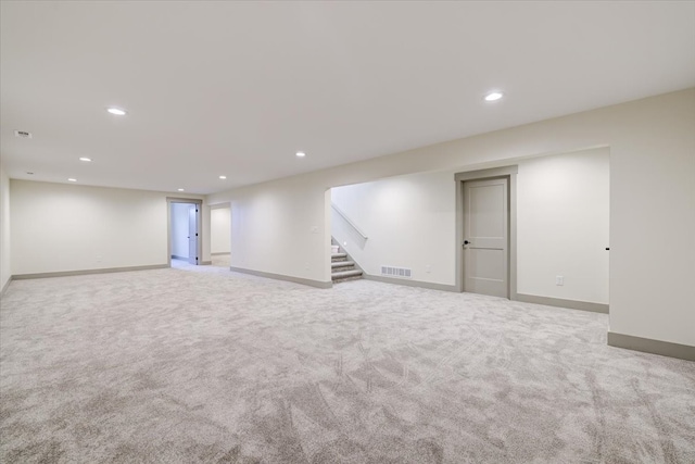 finished basement featuring recessed lighting, visible vents, baseboards, and stairs