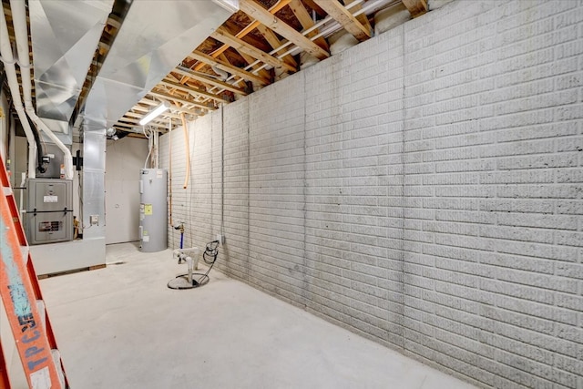 unfinished basement featuring electric water heater and brick wall