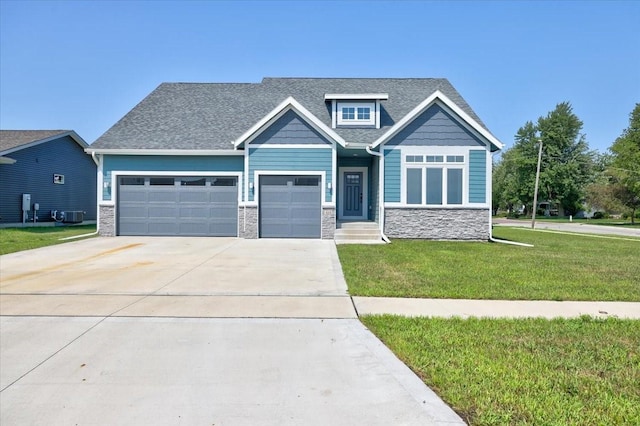 craftsman-style house with concrete driveway, central AC unit, a garage, stone siding, and a front lawn