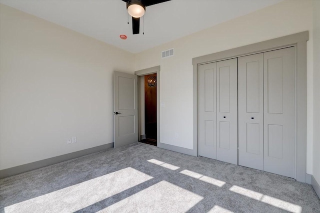 unfurnished bedroom with ceiling fan, carpet flooring, visible vents, baseboards, and a closet