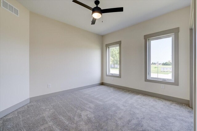 unfurnished room featuring visible vents, ceiling fan, light carpet, and baseboards