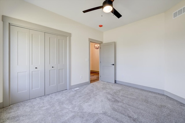 unfurnished bedroom with a ceiling fan, visible vents, baseboards, a closet, and carpet