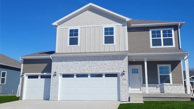 view of front of property with driveway, stone siding, a porch, board and batten siding, and a garage