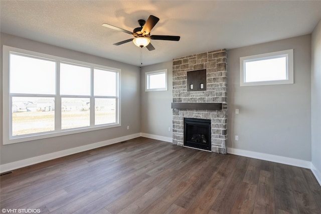 unfurnished living room with a fireplace, hardwood / wood-style flooring, and a healthy amount of sunlight