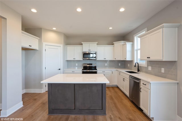 kitchen featuring white cabinets, stainless steel appliances, and light wood-type flooring