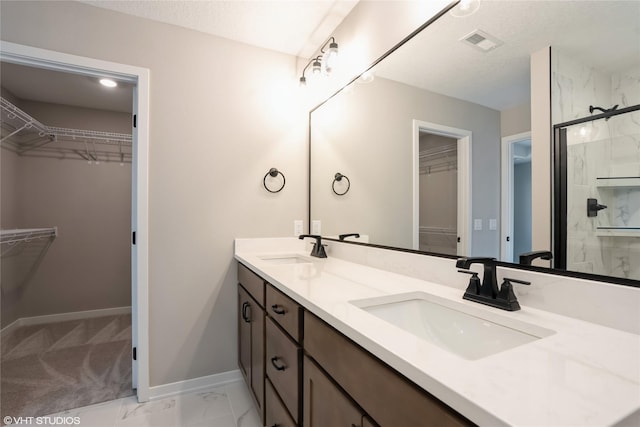 2750 SE Florence Dr, Waukee, IA 50263 - full bathroom with double vanity, baseboards, a spacious closet, a stall shower, and marble look tiles
