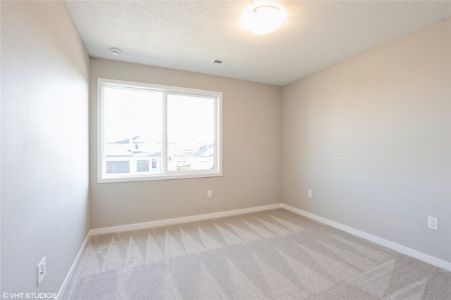 unfurnished room featuring light colored carpet and a textured ceiling