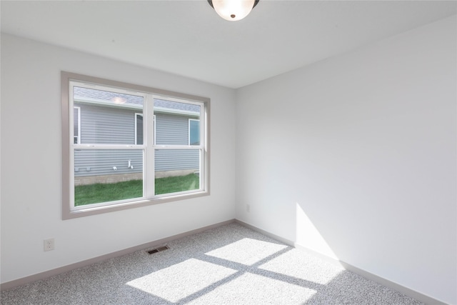 carpeted empty room with visible vents and baseboards