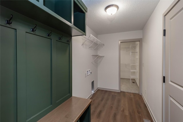 laundry area with a textured ceiling, laundry area, washer hookup, wood finished floors, and baseboards