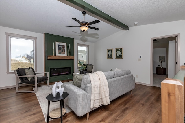 living room featuring lofted ceiling with beams, a large fireplace, a textured ceiling, and dark wood-style flooring