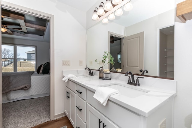 bathroom with double vanity, connected bathroom, a ceiling fan, and a sink