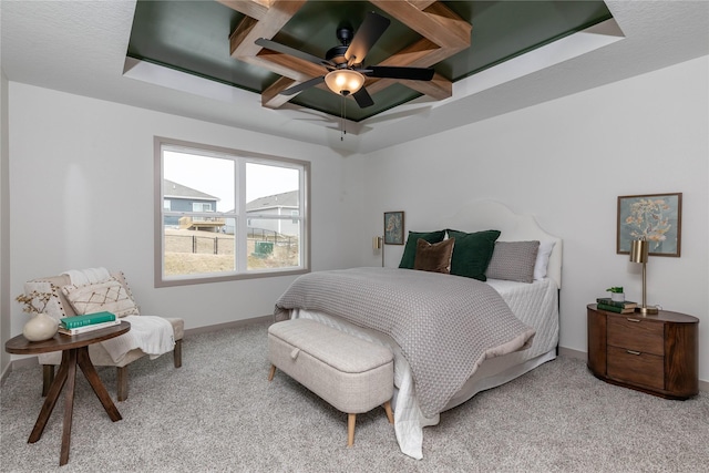 carpeted bedroom featuring a tray ceiling, baseboards, and a ceiling fan