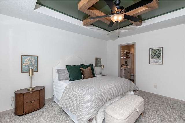 carpeted bedroom featuring a ceiling fan, a tray ceiling, connected bathroom, and baseboards