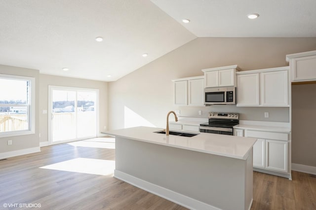 kitchen featuring white cabinetry, sink, a center island with sink, and appliances with stainless steel finishes