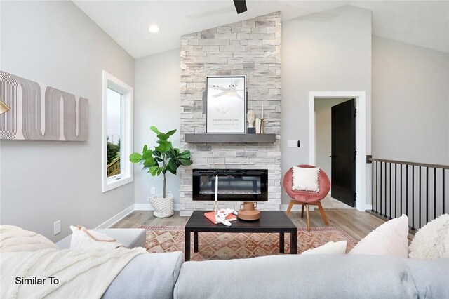 living room featuring lofted ceiling, a fireplace, and light hardwood / wood-style floors