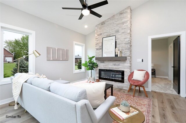 living room with light hardwood / wood-style flooring, a healthy amount of sunlight, and vaulted ceiling