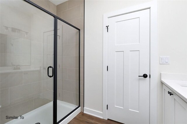 bathroom with vanity, hardwood / wood-style floors, and a shower with shower door