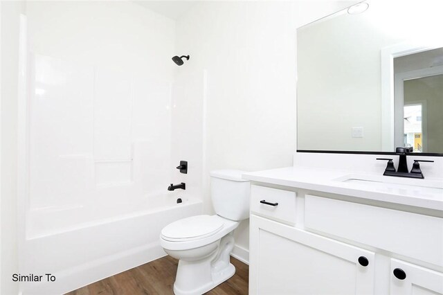 full bathroom with shower / tub combination, wood-type flooring, toilet, and vanity