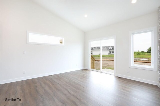 empty room featuring lofted ceiling and wood-type flooring